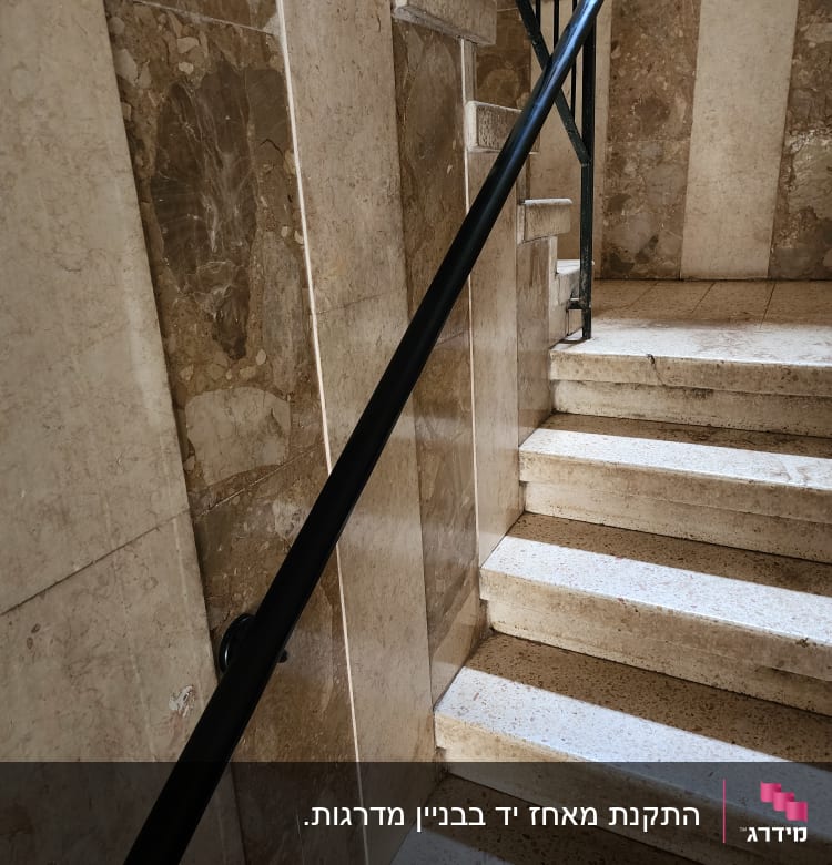 מעקה שחור על מדרגות שיש